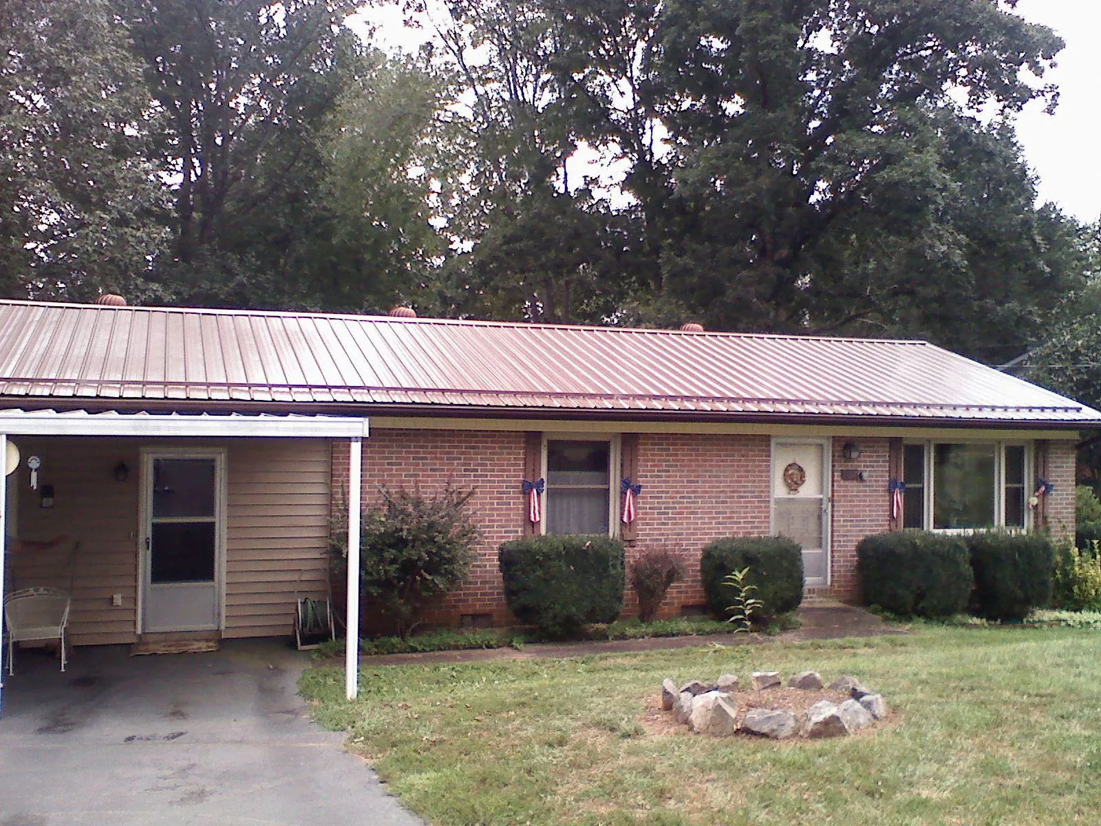 Bronze metal roof and carport on a brick ranch home — Roof Repair work by our crew in Lake Milton