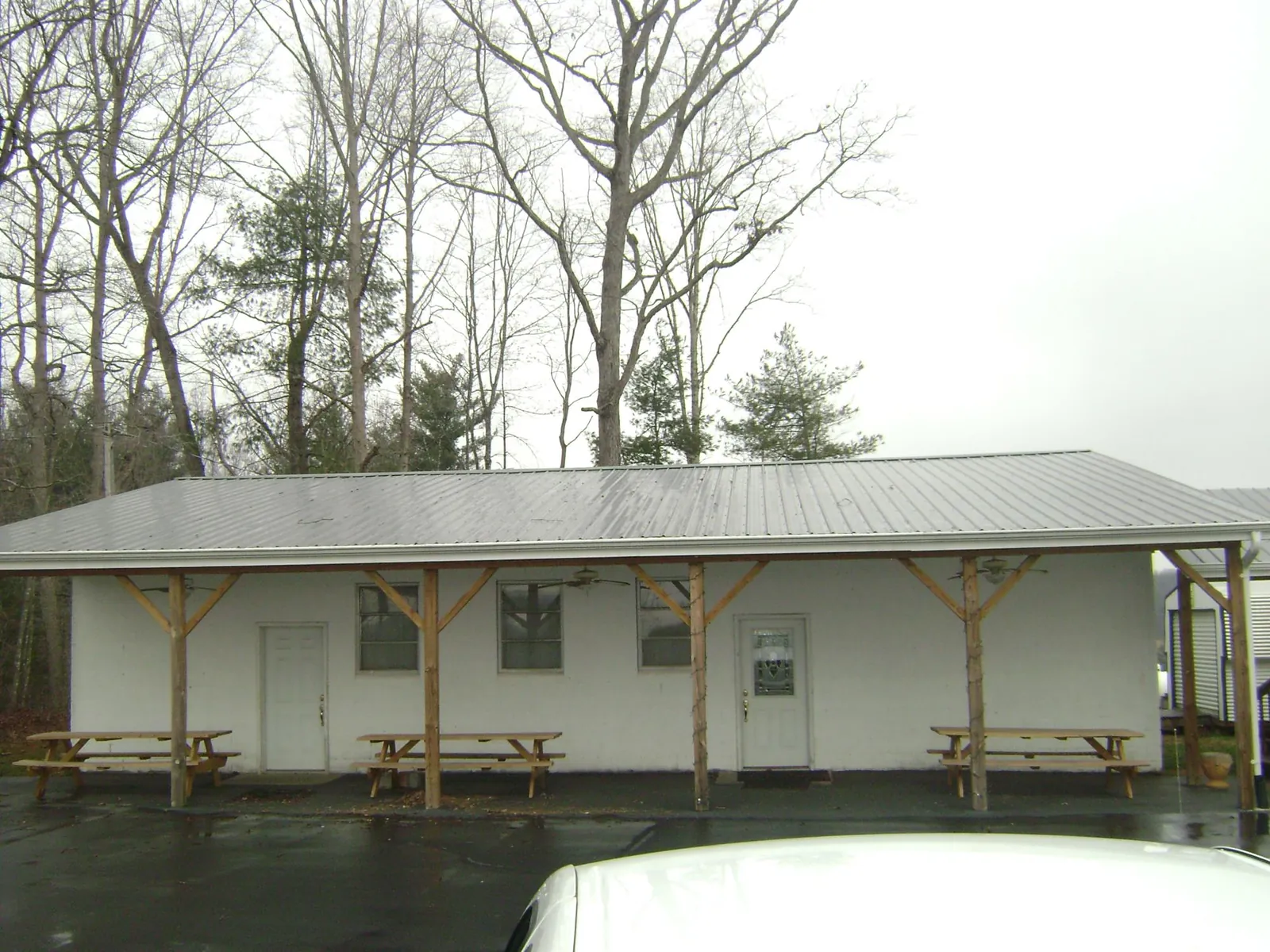 Gray metal roof over a block building with a timber post porch in Lake Milton
